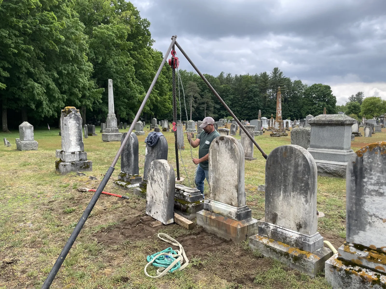 Crew using a tripod hoist for a multi-stone cemetery restoration project